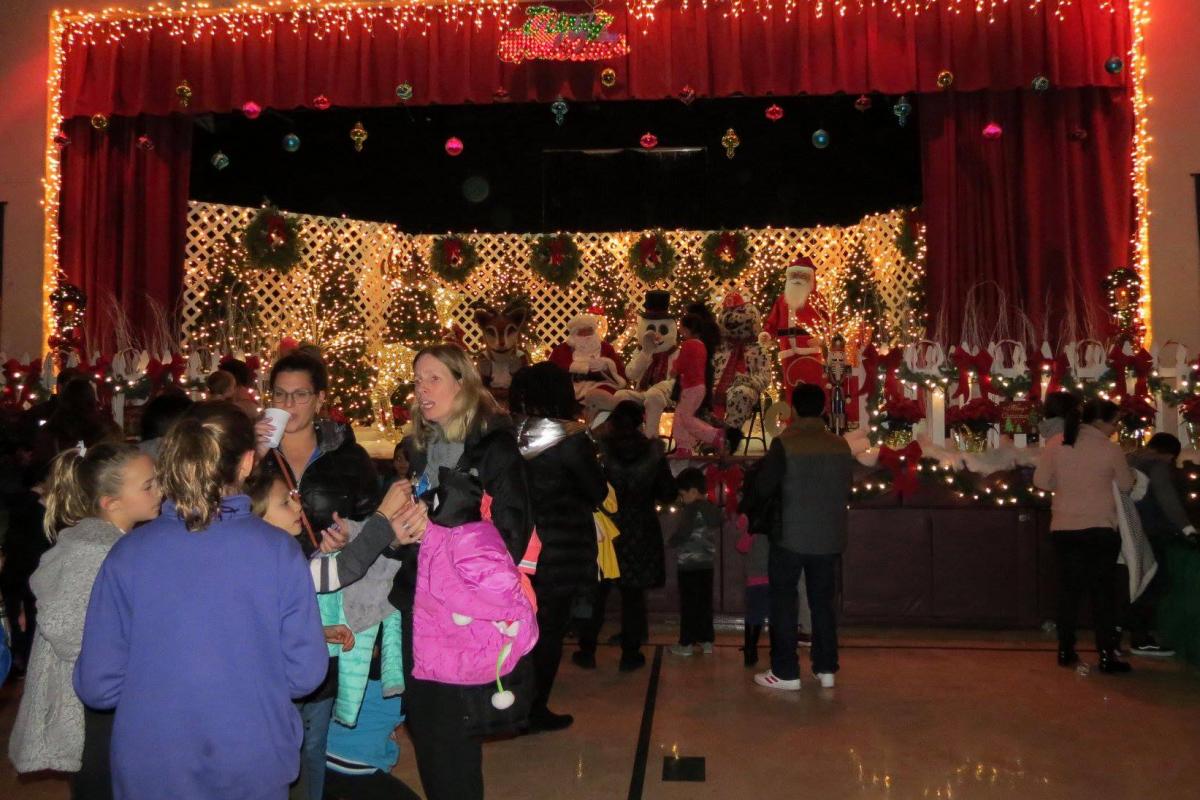 Community center filled with many people and stage decorated with bright lights